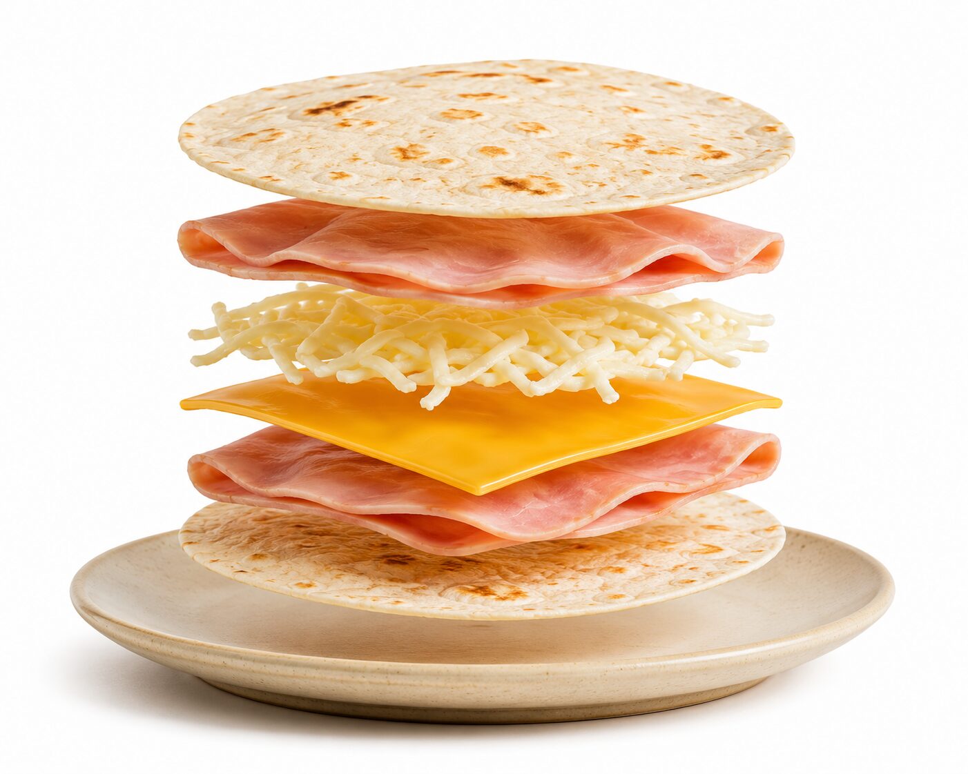 Sincronizada de jamón y queso con ingredientes flotando: tortilla de harina, jamón, queso amarillo tipo americano y quesillo sobre un plato con fondo blanco.