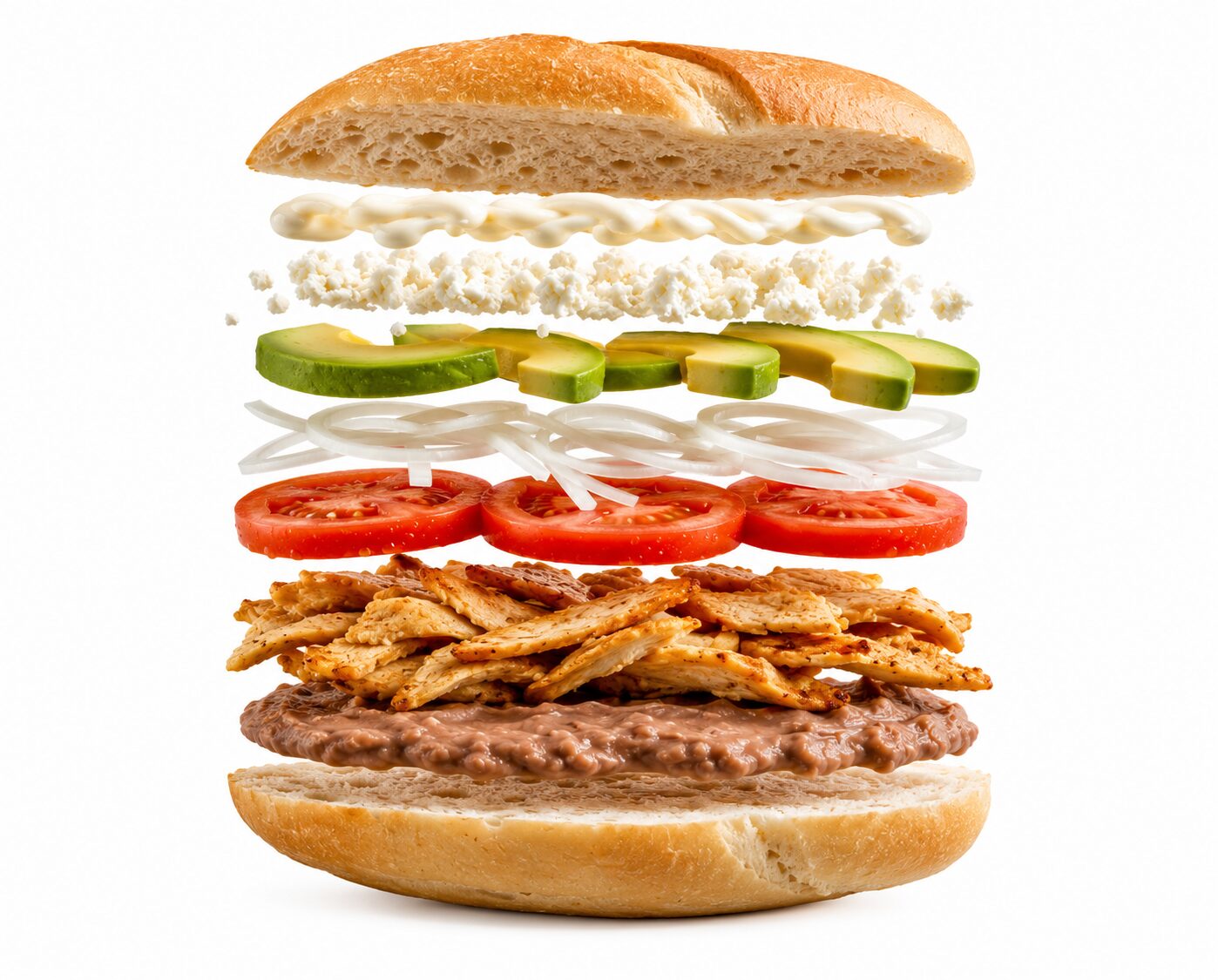 Torta artesanal con ingredientes flotando: bolillo, frijoles, milanesa de pollo o res, jitomate, cebolla blanca, aguacate, queso blanco y mayonesa sobre fondo blanco.